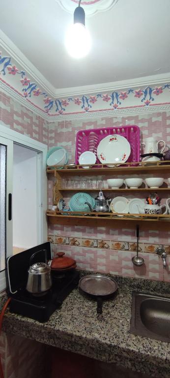 cocina con encimera con platos y fregadero en Casa Lotfi, en Chefchaouen