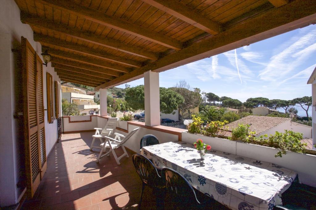 eine Terrasse mit einem Tisch und Stühlen auf dem Balkon in der Unterkunft Clara Vista Mare - Goelba in Seccheto