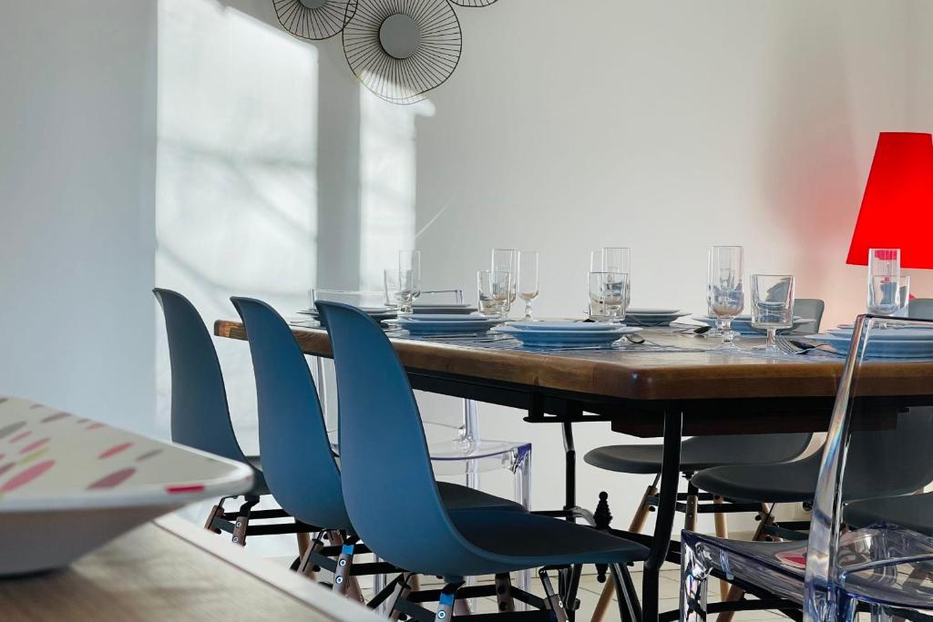 une table à manger avec des chaises bleues et une lampe rouge dans l'établissement The House of the Green Way a charming pied-à-terre for your walks in Toura, à Joué-lès-Tours