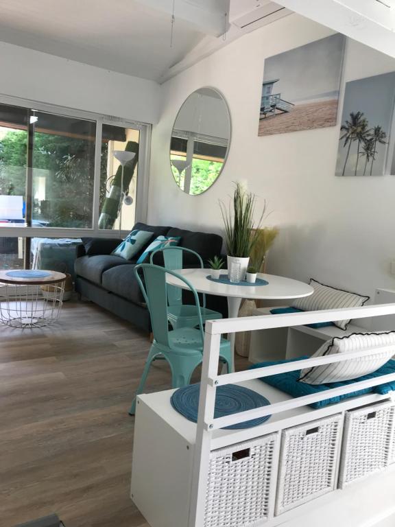 ein Wohnzimmer mit einem Sofa und einem Tisch in der Unterkunft Maison à 300m de la plage, quartier calme in Mimizan