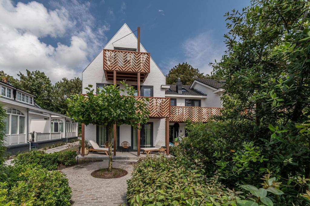 ein großes weißes Haus mit spitzem Dach in der Unterkunft Villa Noordzee in Renesse