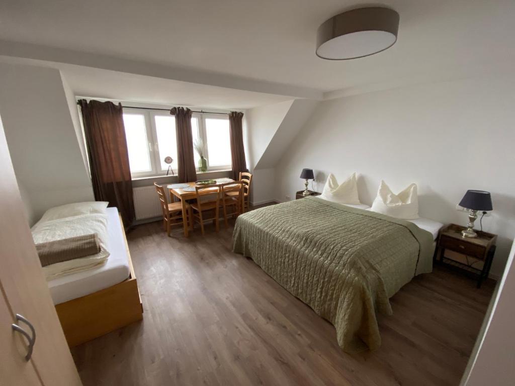 um quarto com uma cama, uma mesa e cadeiras em Pension Haus Talblick em Winterberg