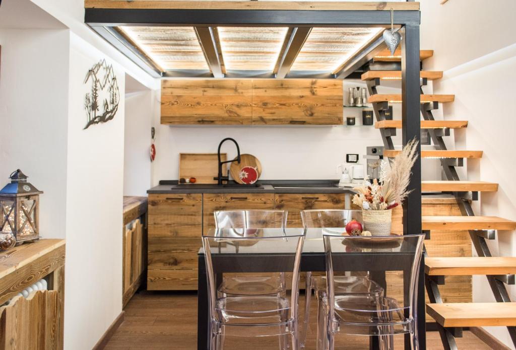 una cucina con armadi in legno, tavolo e sedie di Mon Petit Cervin a Valtournenche