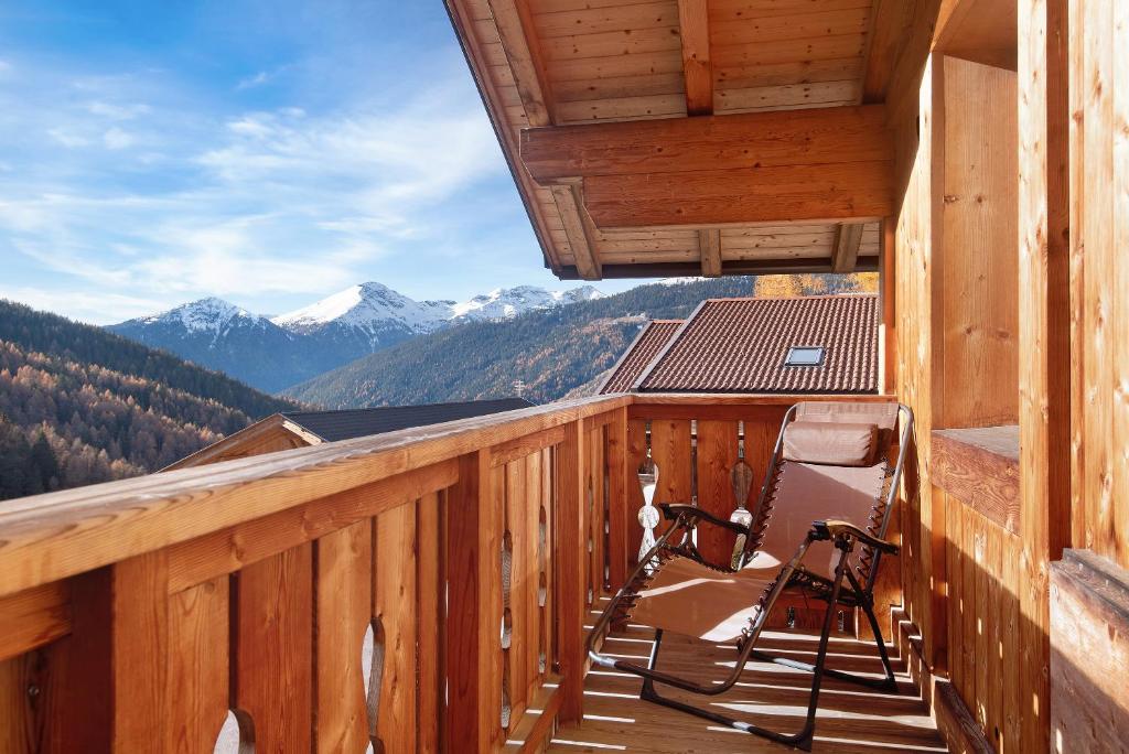 a balcony with a chair and a view of mountains at Apt Talblick Hinterproslhof in Sarntal
