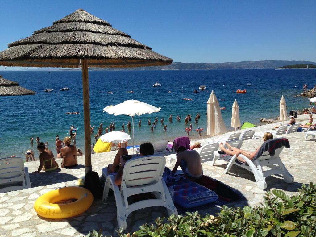 a group of people sitting in chairs on a beach at Easyatent Safari tent Comfort Krk in Krk