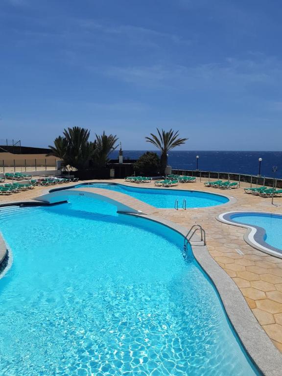 a swimming pool with the ocean in the background at Westhaven Bay in Costa Del Silencio