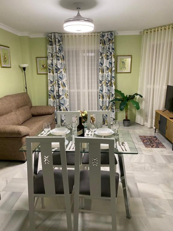 Apartamento céntrico “Los Pajaritos” con garaje. في خيريز دي لا فرونتيرا: طاولة طعام وكراسي في غرفة المعيشة