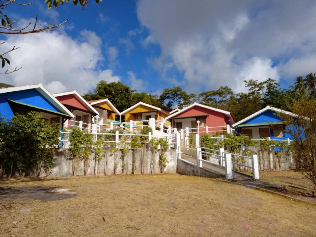 una fila de casas detrás de una valla en Villa Manary, en Itamaracá