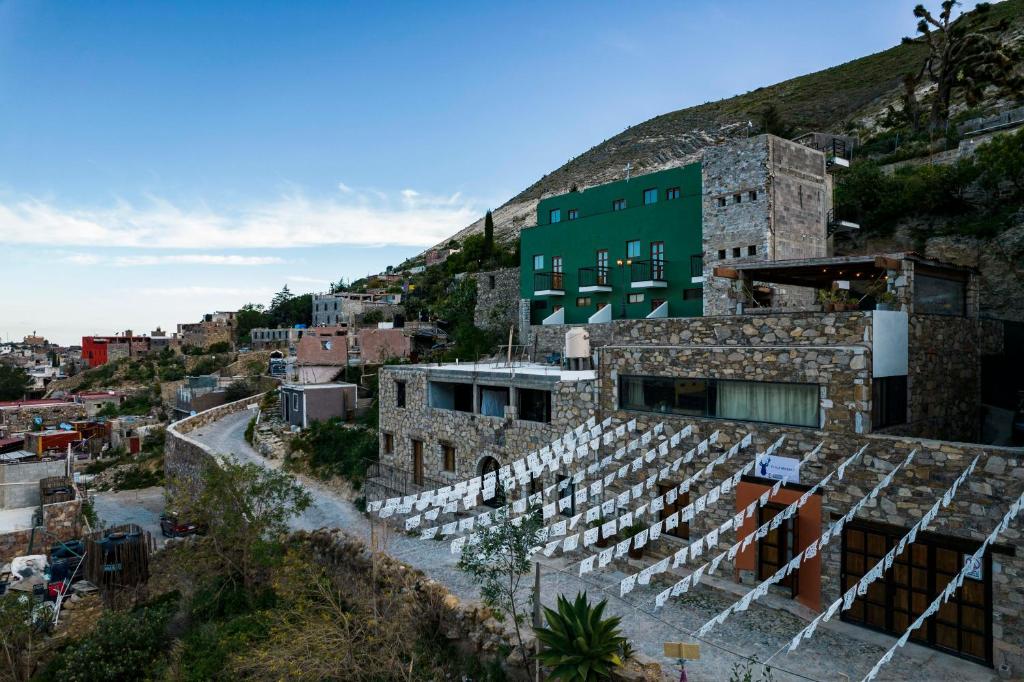 um edifício numa colina com cadeiras brancas em Villa Mosaico - Luxury Lofts em Real de Catorce