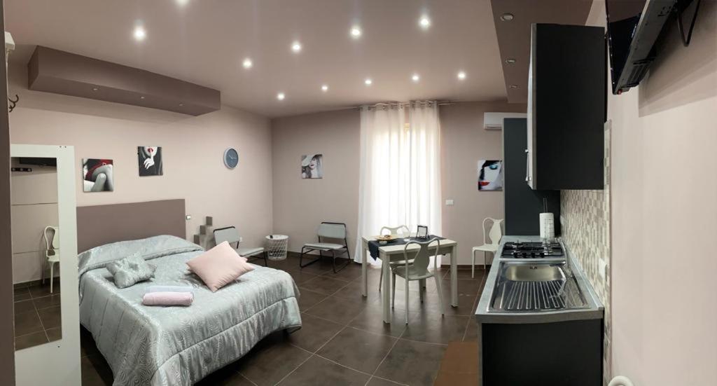 a bedroom with a bed and a table and a kitchen at La casa di Francesca in Campobello di Licata