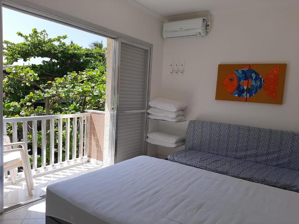- une chambre avec un lit et un balcon avec une fenêtre dans l'établissement Apto 1 dorm Guarujá, Enseada, 1 quadra da praia, à Guarujá