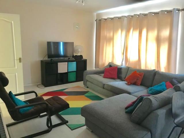 a living room with a couch and a chair at CROYDON Spacious 3 Bedroom Family House in Addington