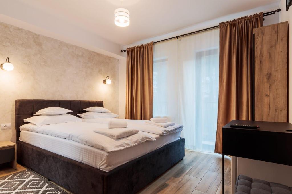- une chambre avec un grand lit et un bureau dans l'établissement Pensiunea Doro, à Călimăneşti