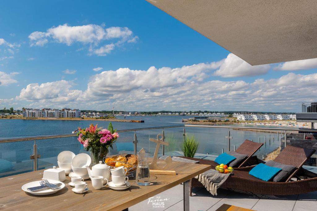 a table on a balcony with a view of the water at Sky 65 in Olpenitz