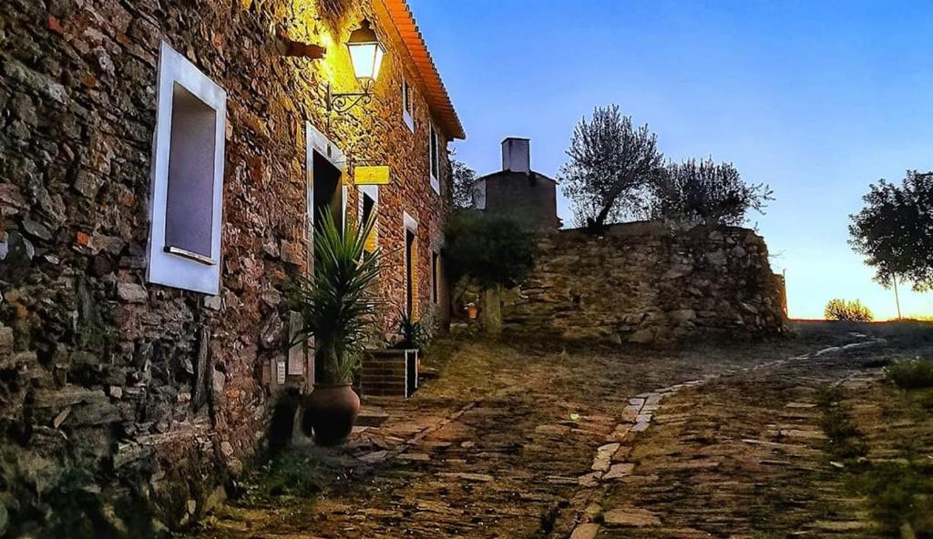 un edificio de ladrillo con una maceta al lado en Refúgio da Vila en Monsaraz