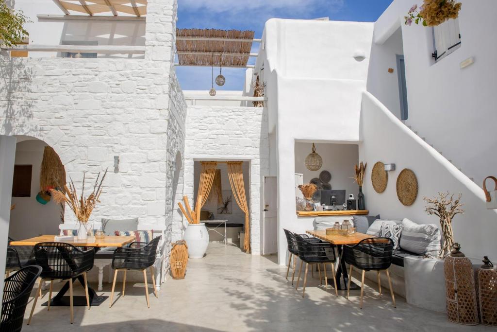 a patio with tables and chairs in a white building at 8 Keys Residence in Naousa