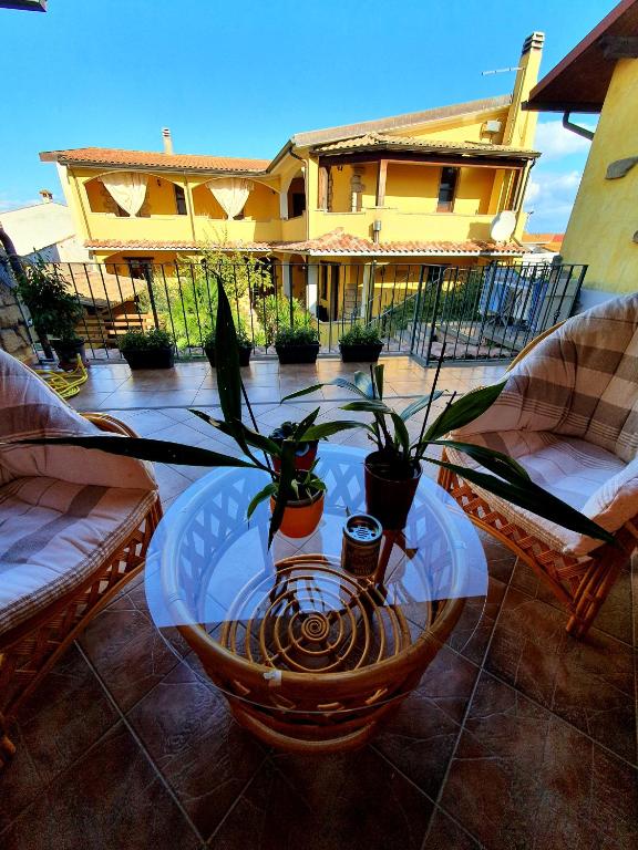 a table with potted plants on a patio at Sinis Apartment in Palmas Arborea