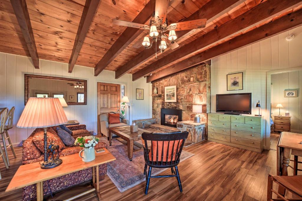 a living room with a couch and a table and a television at Sweet Birch Bryson City Cottage with Views in Bryson City