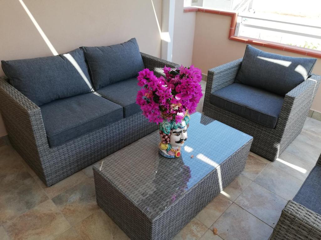 a living room with a couch and a table with flowers at Casa Veronica in Marzamemi