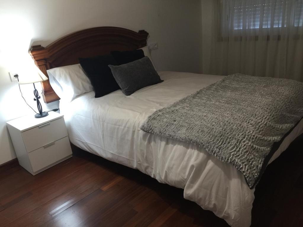 een slaapkamer met een groot bed met een nachtkastje en een bed sidx sidx sidx bij Casa compartida in Vigo