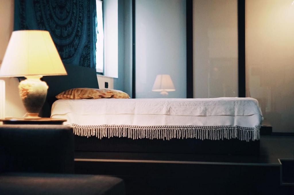 - une chambre avec un lit et une lampe sur une table dans l'établissement Casa Falco, à Turin