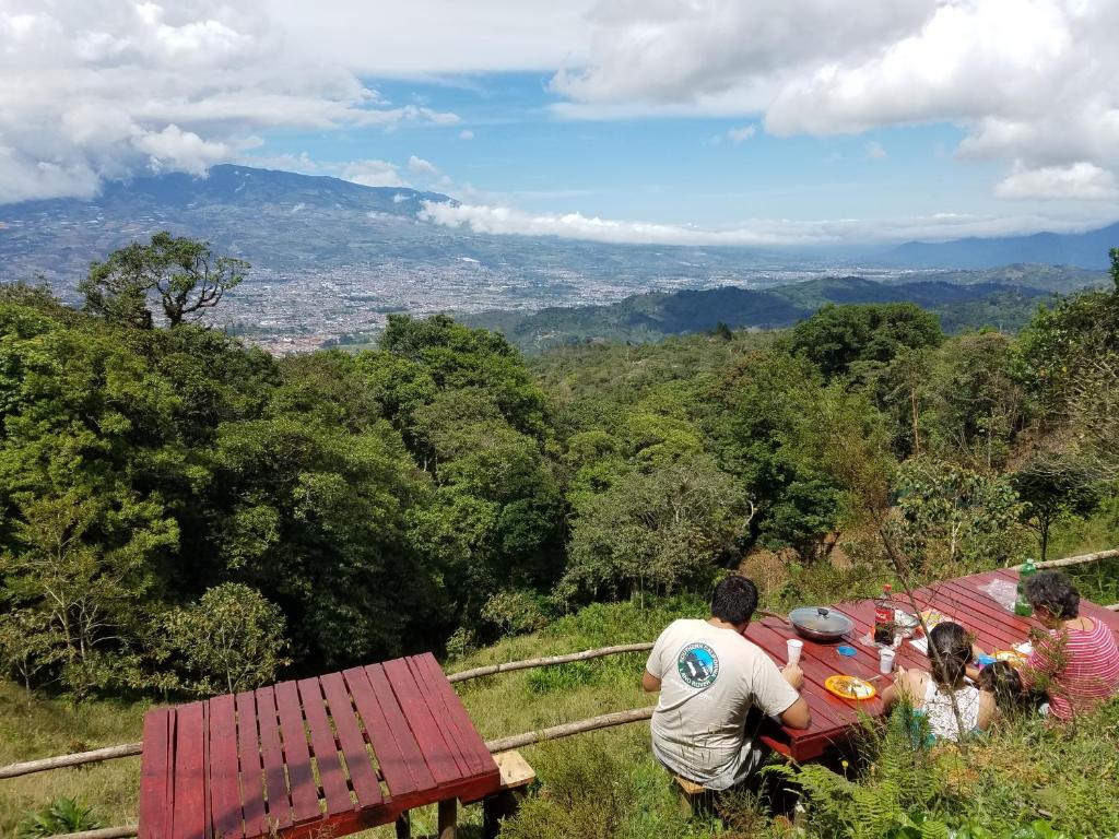 Un groupe de personnes assises à une table sur une colline dans l'établissement Escapadita al Bosque, à San Isidro
