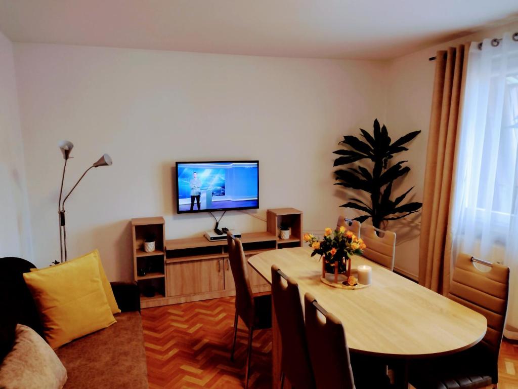 a living room with a table and a television at ApartamentEMILKA in Kudowa-Zdrój