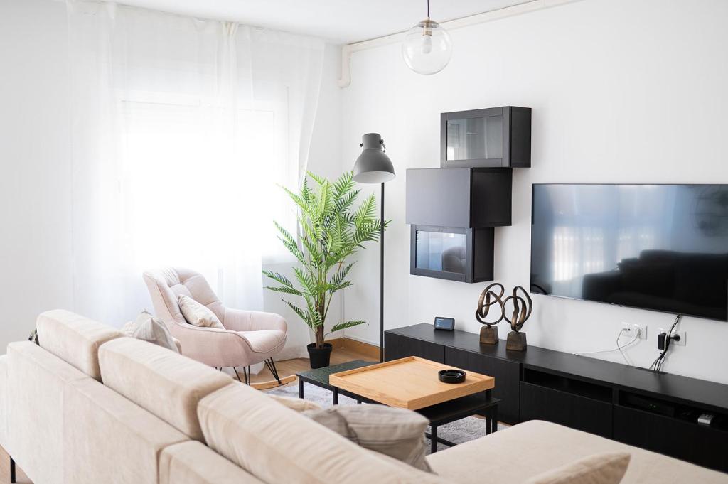a living room with a white couch and a tv at Expoholidays - General Tamayo PARKING gratis in Almería