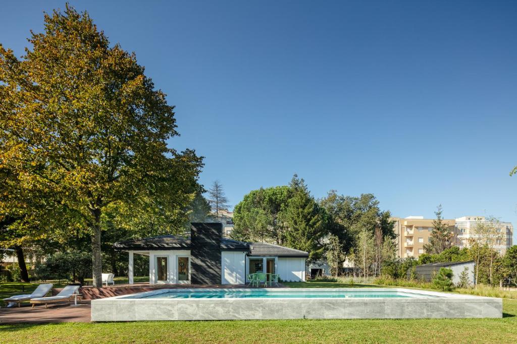 a house with a swimming pool in a yard at 70's wood house in Maia