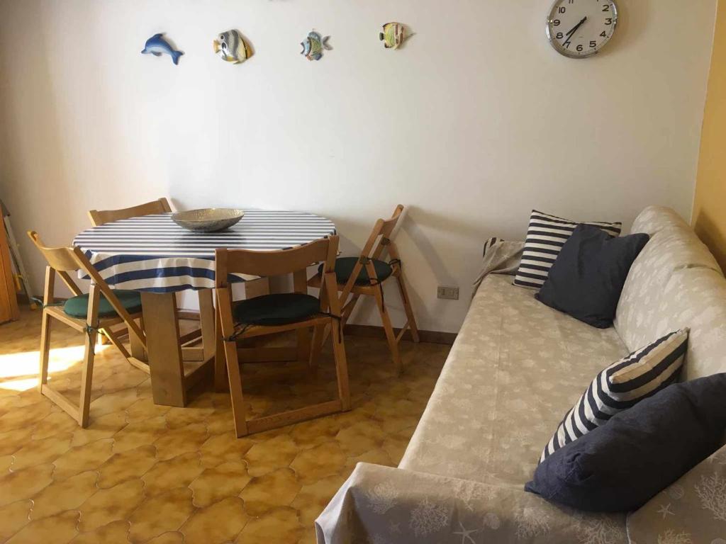 a living room with a couch and a table and a clock at Pitosforo in Zoagli