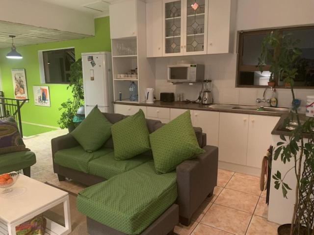 uma sala de estar com um sofá e uma cozinha em 7 on Jansenstreet em Cidade do Cabo