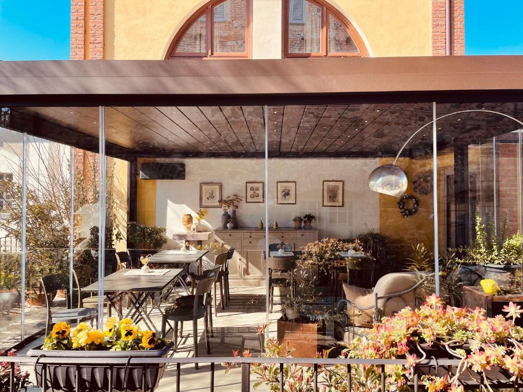 un patio esterno con tavoli, sedie e fiori di Spazio[Bianco] a Ivrea