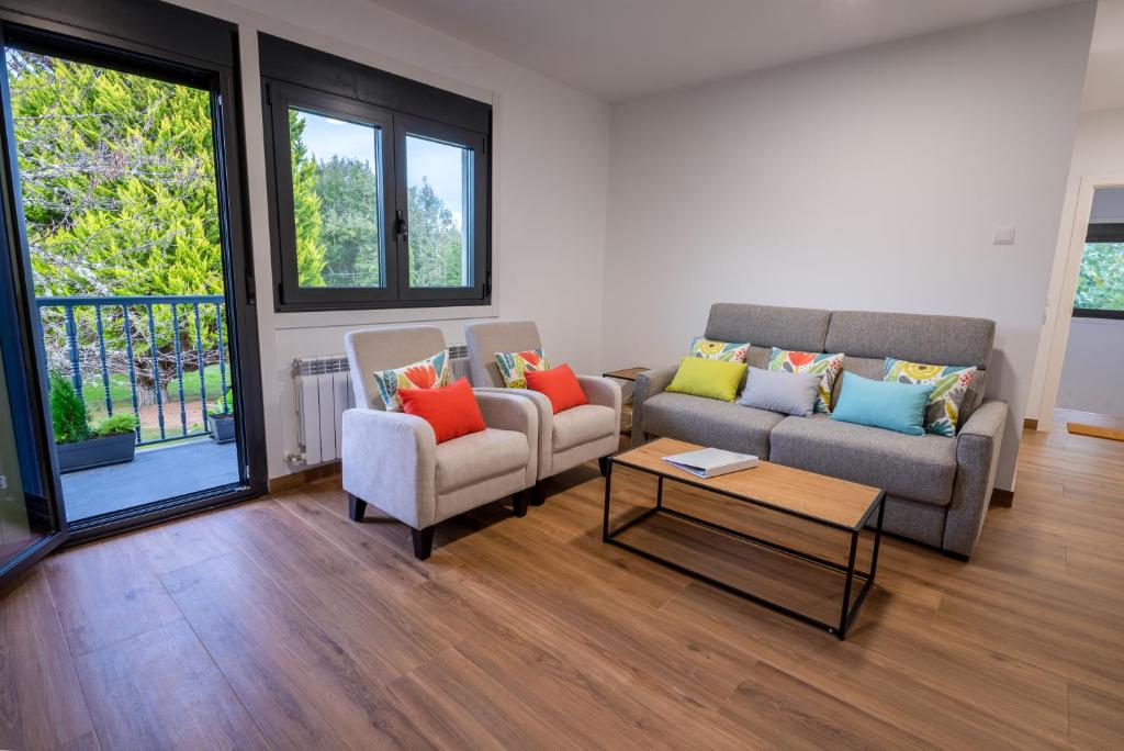 een woonkamer met twee banken en een salontafel bij Finca Bacelo Ribeira Sacra in Sober