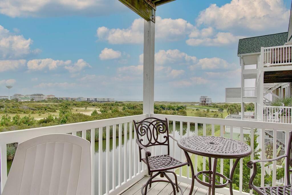 a balcony with a table and chairs on a porch at Oceanview 4BR/4BA Condo, Steps to Beach/Pool in Ocean Isle Beach