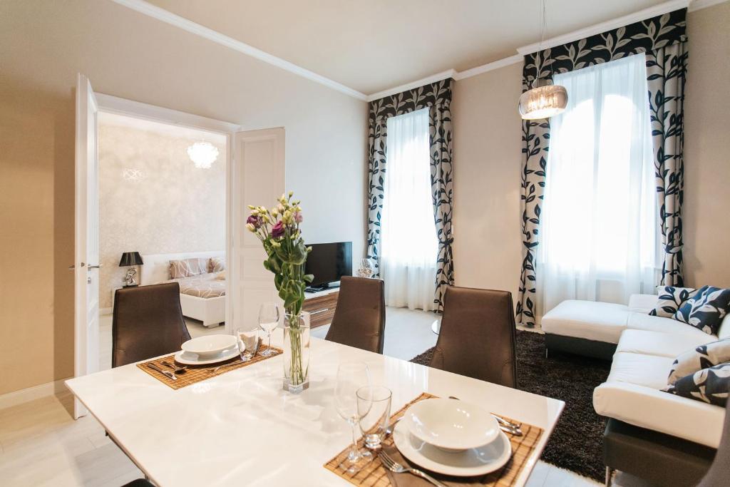 een eetkamer en een woonkamer met een tafel en stoelen bij Parliment Luxury Apartment in Boedapest