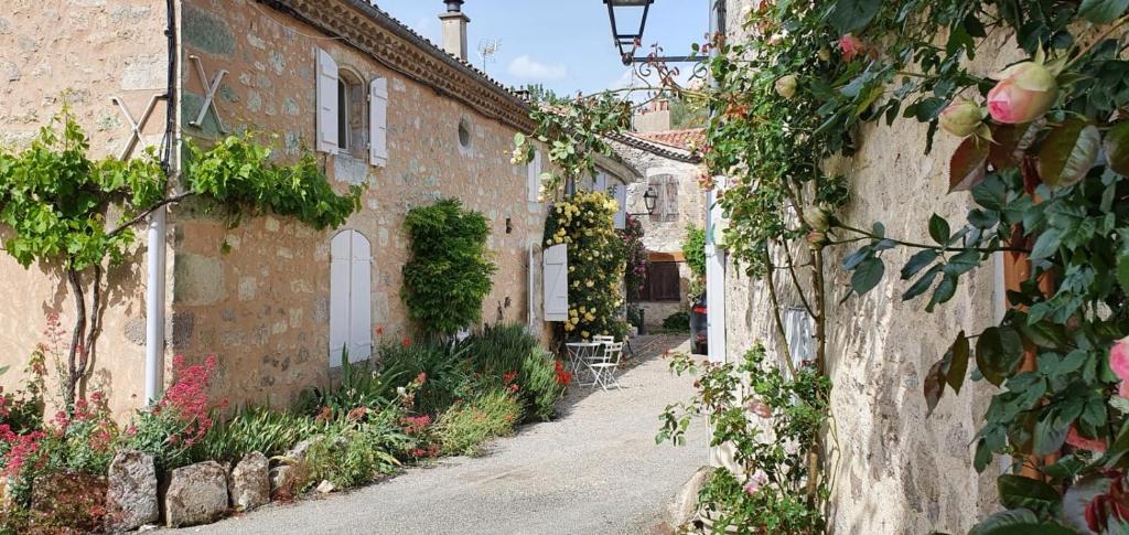 un callejón en un pueblo italiano con flores en La Maison des Cornières en Fourcès
