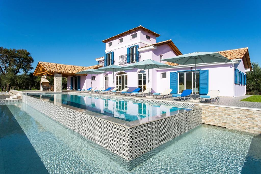 eine Villa mit einem Pool vor einem Haus in der Unterkunft Aneli Luxury Villas - Villa Alexandra in Áyios Kírikos