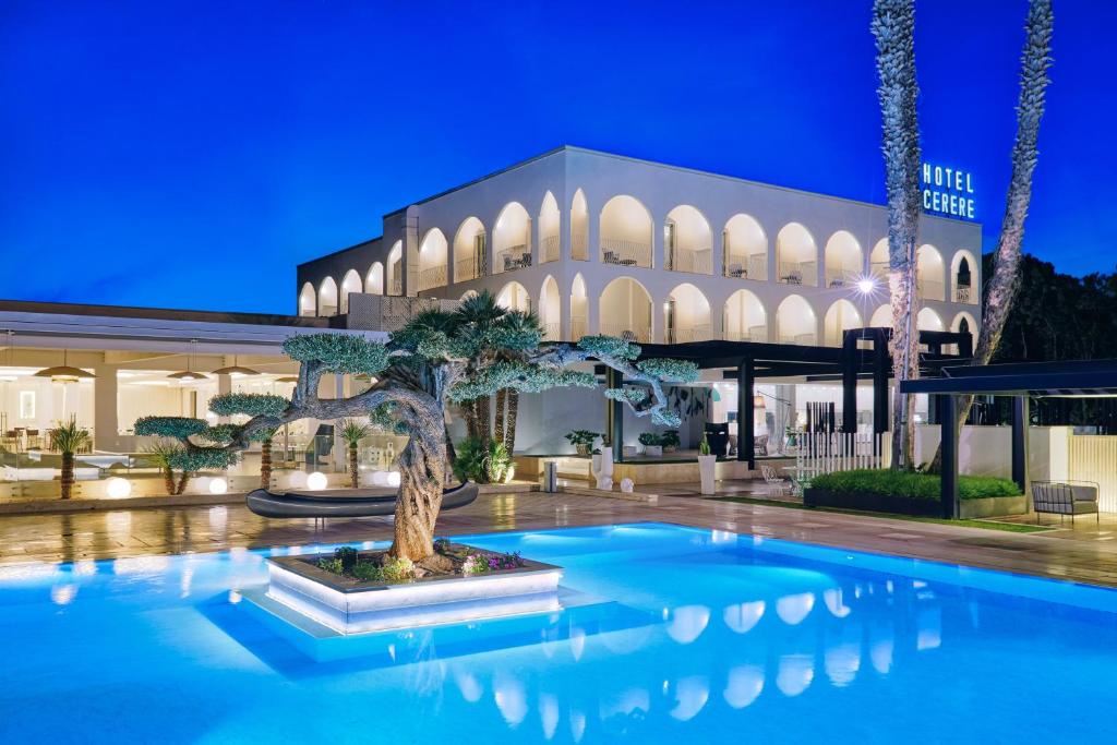 uma árvore bonsai em frente a um edifício à noite em Hotel Cerere em Paestum