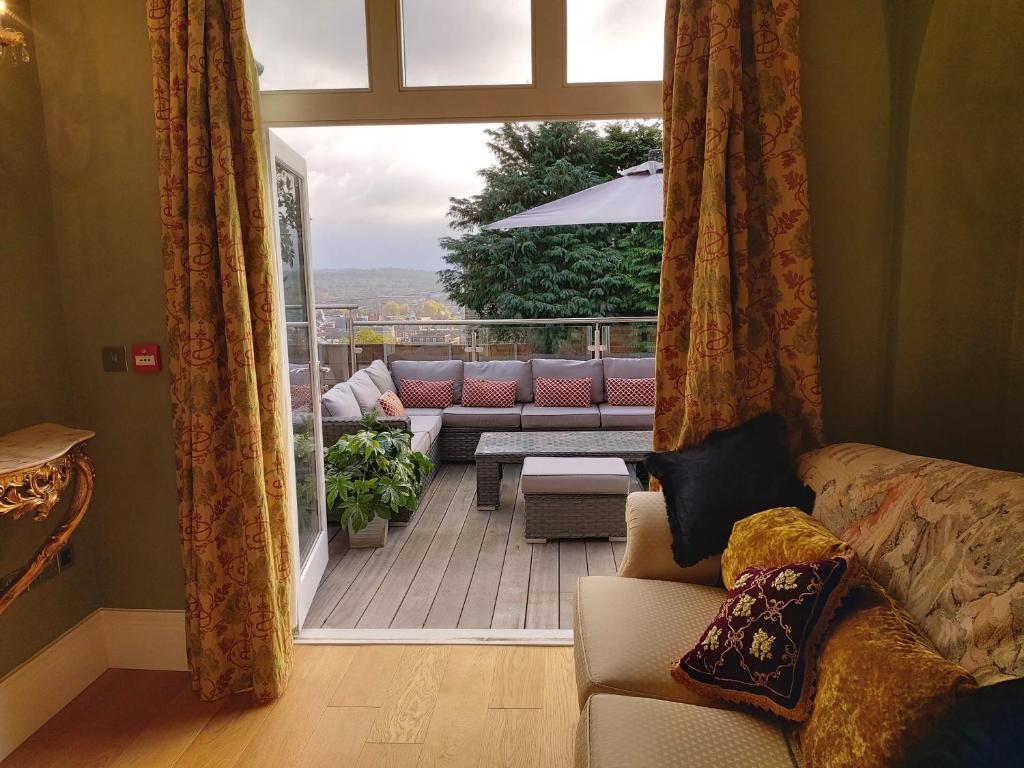 a living room with a balcony with a couch and a patio at The Rector's Retreat at the Old Vicarage in Lincoln