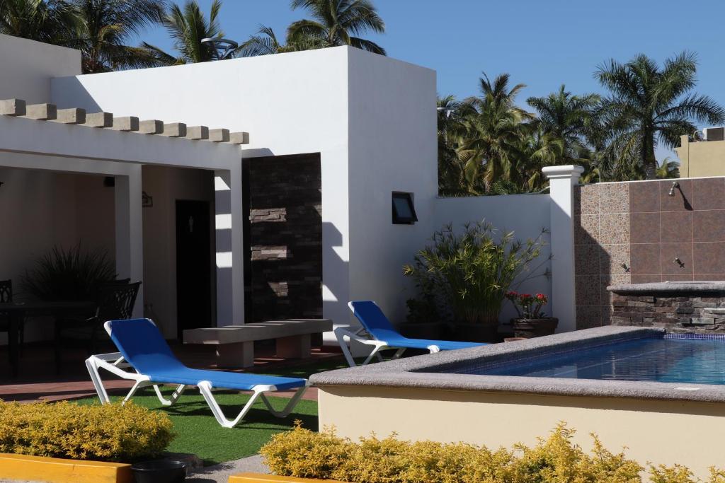 une maison avec deux chaises et une piscine dans l'établissement Mar Sol Bungalows & Hotel, à Mazatlán