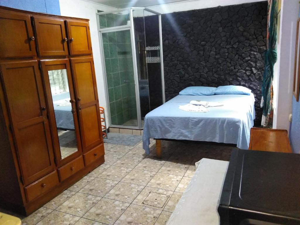um quarto com uma cama e uma porta de vidro em Hotel Marruecos C.R. em San José