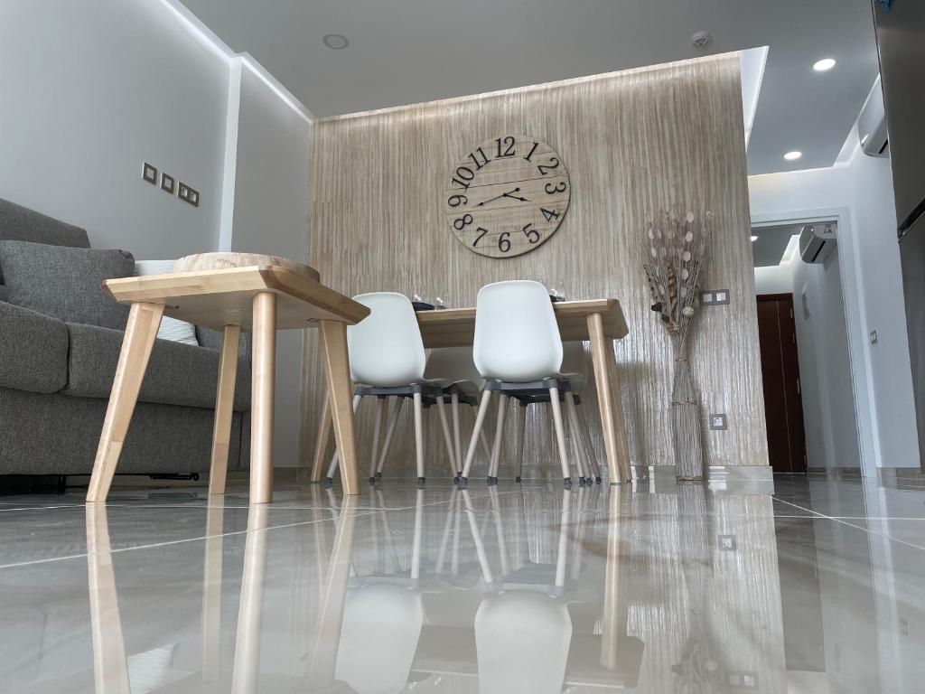 a dining room with a table and a clock on a wall at BAMBOO CHIC APARTMENT PLAYA DEL INGLES in Playa del Ingles