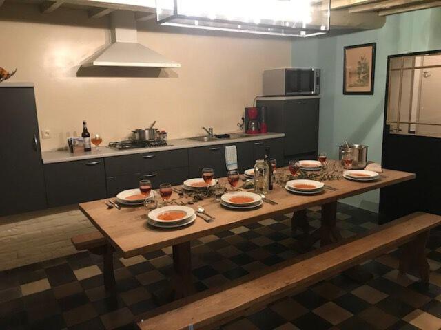 una mesa en una cocina con platos y vasos. en Gite Maison Alfred Soussigne, en Olloy-sur-Viroin