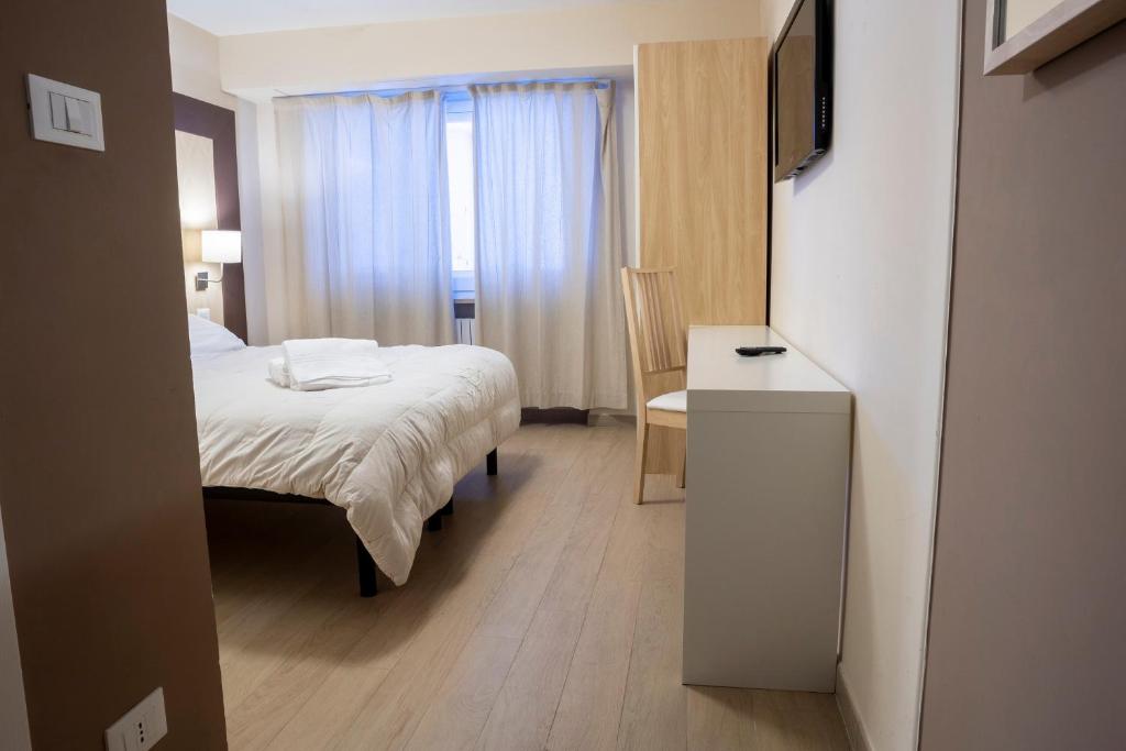 sypialnia z łóżkiem, biurkiem i telewizorem w obiekcie Hotel Hermitage w mieście Sestriere