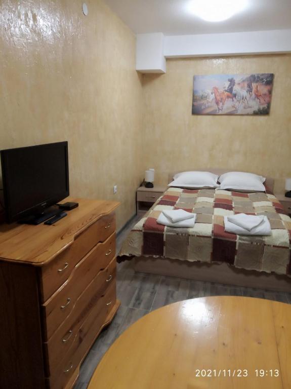 1 Schlafzimmer mit 2 Betten und einem Flachbild-TV in der Unterkunft Studio Mariela in Warna