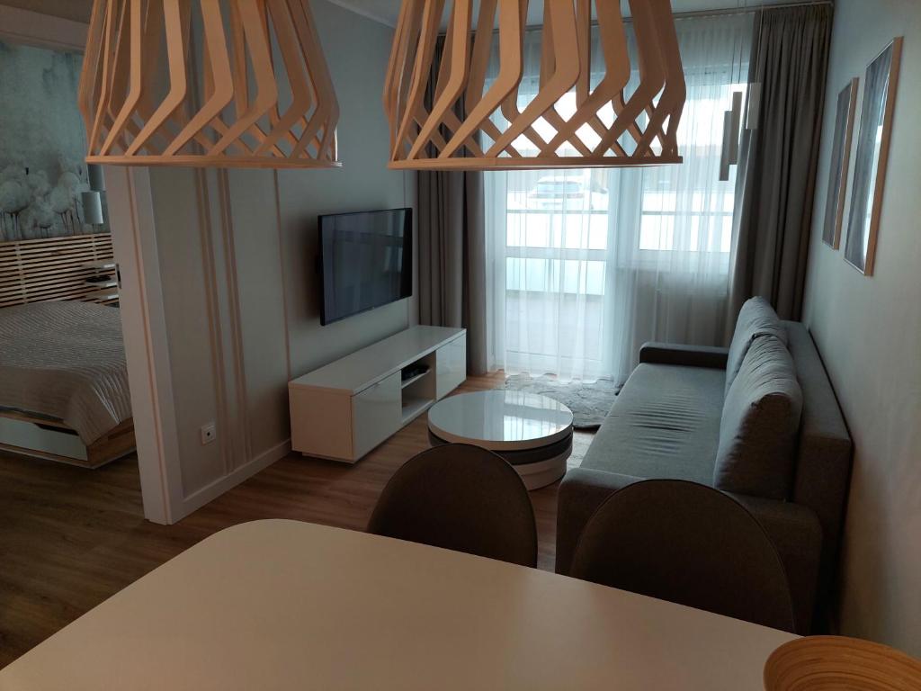 a living room with a couch and a television at Apartament na Kasprowicza in Kołobrzeg