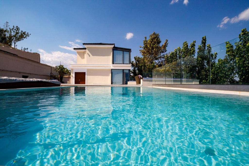 a swimming pool in front of a house at KingsResidenceVilla in Nafplio