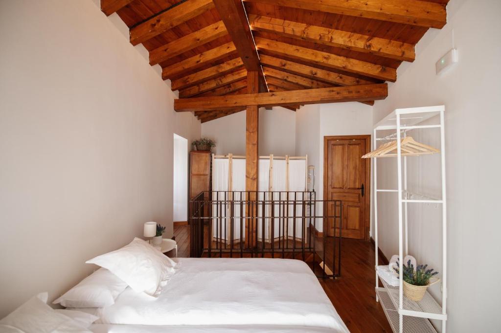 a bedroom with a bed with a wooden ceiling at El Postigo in Trujillo