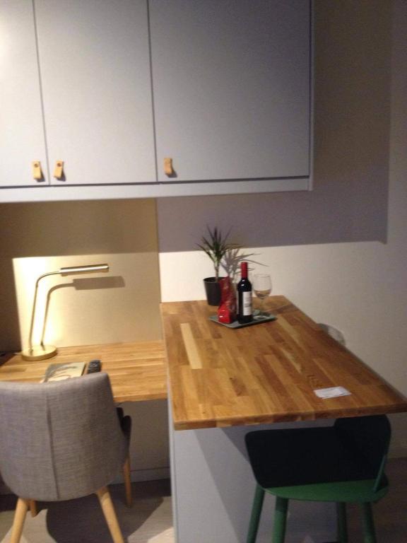 a kitchen with a table with a bottle of wine on it at Avanti Apartment Hotel in Stockholm