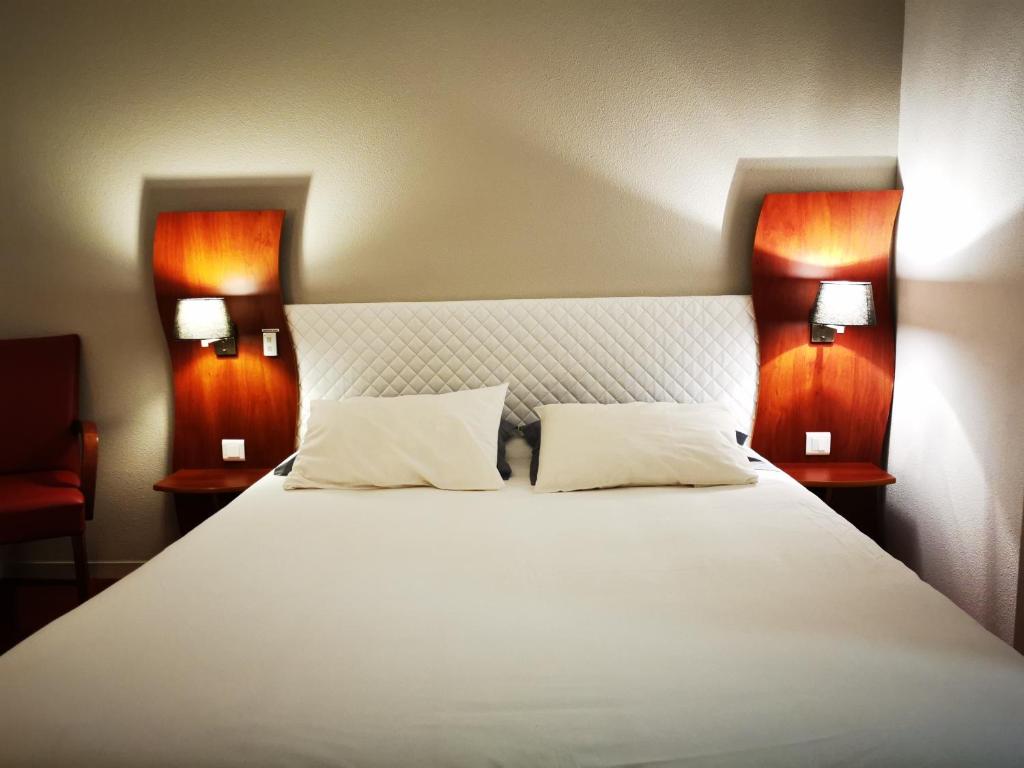 ブリウドにあるArtémis Hôtel & Spa Bistro Coquetのベッドルーム(白い大型ベッド、ランプ2つ付)